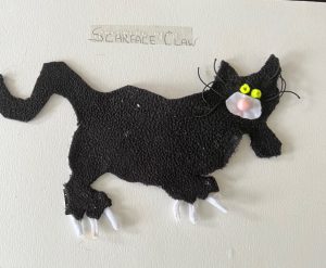 A picture of a cat called Scarface claw which is done in black velvet